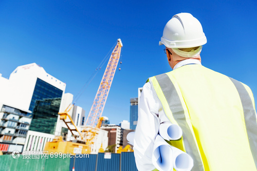 建筑工地的工程師建設者工程師建筑工人施工場景穿著帶藍圖的安全背心